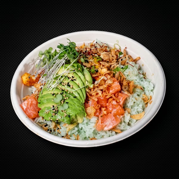 A colorful poke bowl with salmon, avocado, sprouts, crispy onions, and light green rice.